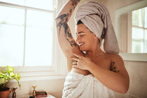 Smiling woman just out of shower with towels around her body and her head