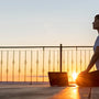 Woman doing yoga following online lessons on her balcony