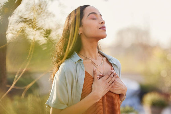 Meditating woman against an unfocused nature background